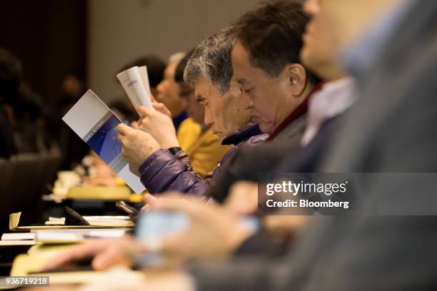 Shareholders look at annual reports during the Samsung Electronics Co. Annual general meeting at the company's Seocho office building in Seoul, South...