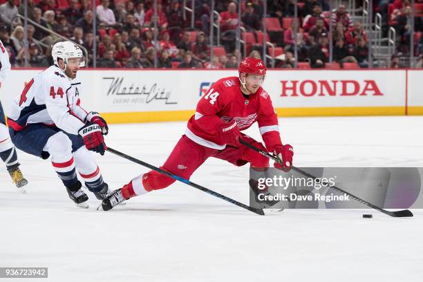 Gustav Nyquist of the Detroit Red Wings skates with the puck in front of Brooks Orpik of the Washington Capitals during an NHL game at Little Caesars...