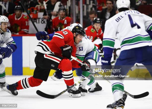 Troy Stecher of the Vancouver Canucks hits Brandon Saad of the Chicago Blackhawks at the United Center on March 22, 2018 in Chicago, Illinois.