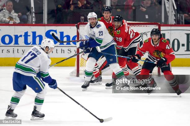 Vancouver Canucks defenseman Alexander Edler battles with Chicago Blackhawks left wing Andreas Martinsen , Chicago Blackhawks defenseman Connor...