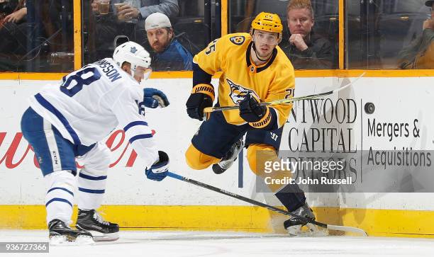 Alexei Emelin of the Nashville Predators passes the puck against Andreas Johnsson of the Toronto Maple Leafs during an NHL game at Bridgestone Arena...