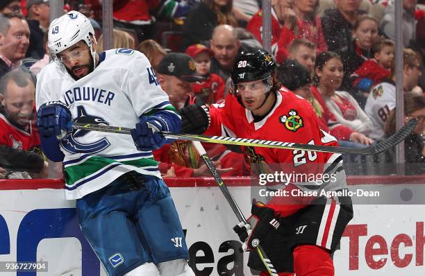 Darren Archibald of the Vancouver Canucks and Brandon Saad of the Chicago Blackhawks watch for the puck in the third period at the United Center on...