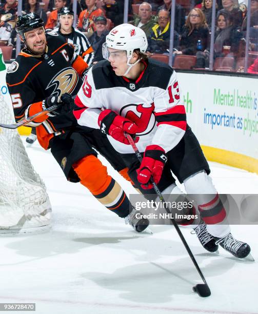 Nico Hischier of the New Jersey Devils skates with the puck with pressure from Ryan Getzlaf of the Anaheim Ducks during the first period of the game...