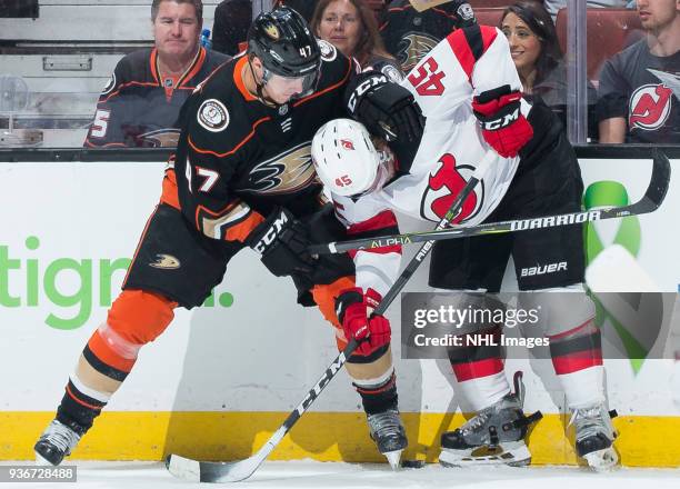 Hampus Lindholm of the Anaheim Ducks and Sami Vatanen of the New Jersey Devils battle for the puck against the boards during the first period of the...