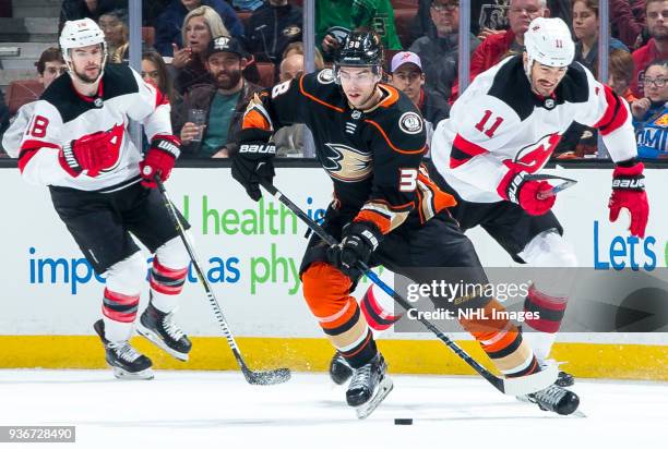 Derek Grant of the Anaheim Ducks skates with the puck with pressure from Brian Boyle of the New Jersey Devils during the first period of the game at...