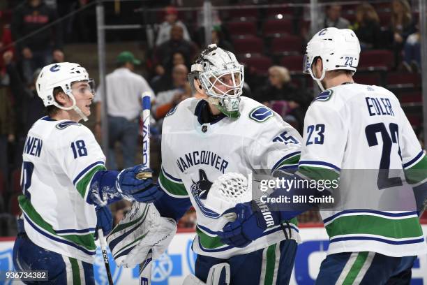 Goalie Jacob Markstrom of the Vancouver Canucks celebrates with Jake Virtanen and Alexander Edler after defeating the Chicago Blackhawks 5-2 at the...