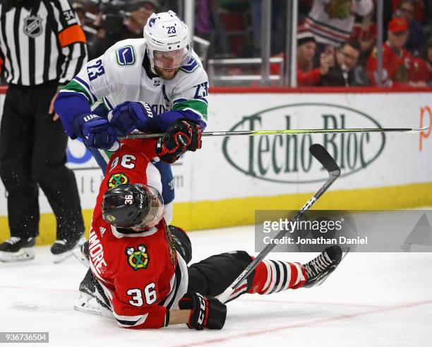Alexander Edler of the Vancouver Canucks hits Matthew Highmore of the Chicago Blackhawks with his stick at the United Center on March 22, 2018 in...