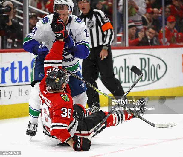 Alexander Edler of the Vancouver Canucks and Matthew Highmore of the Chicago Blackhawks tussle on the ice at the United Center on March 22, 2018 in...