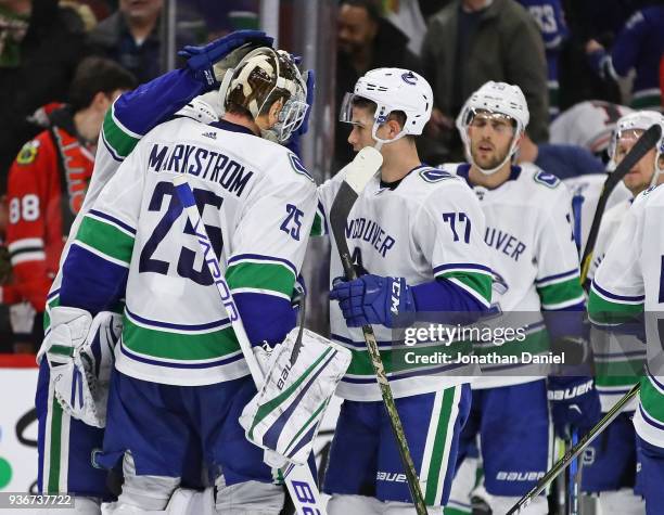 Jacob Markstrom of the Vancouver Canucks is congratulated by teammates including Nikolay Goldobin after a win over the Chicago Blackhawks at the...