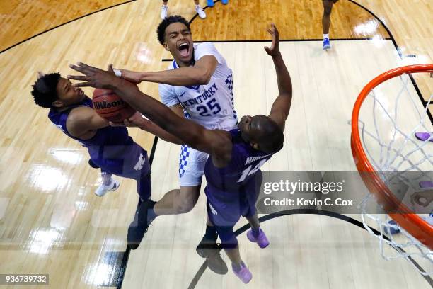 Washington of the Kentucky Wildcats goes up with the ball against Amaad Wainright and Makol Mawien of the Kansas State Wildcats in the second half...