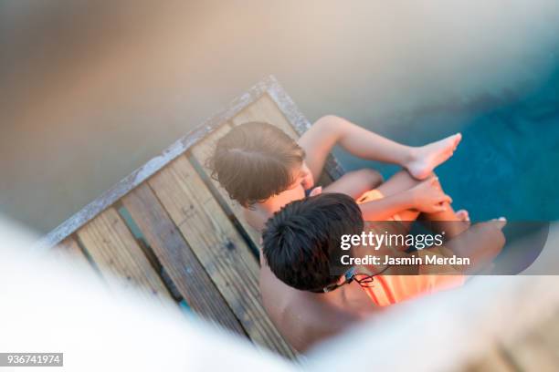 two young boys sitting on jetty - dip toe stock pictures, royalty-free photos & images