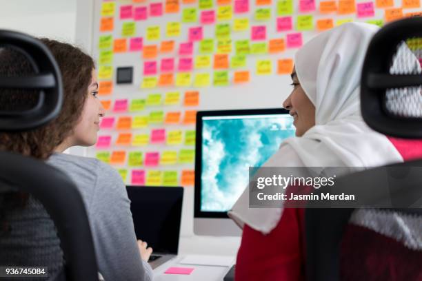 two muslim girls working on computer - jalabib imagens e fotografias de stock