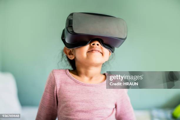 girl wearing virtual reality headset at home - vr kids stock pictures, royalty-free photos & images