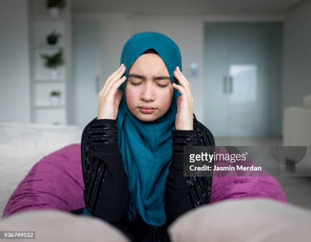 worried and nervous muslim girl - teenager headache stock pictures, royalty-free photos & images