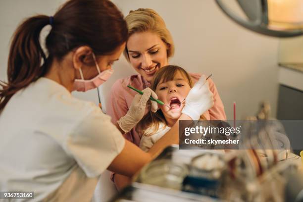 little girl with her mother having dental examination at dentist's. - plaque remover stock pictures, royalty-free photos & images