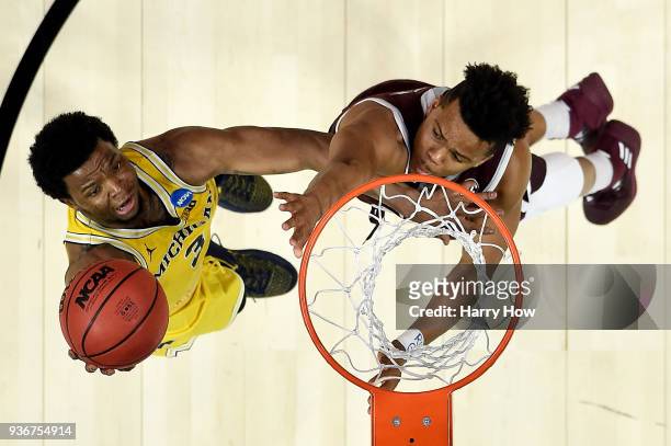 Zavier Simpson of the Michigan Wolverines goes up for a shot against the Texas A&M Aggies in the 2018 NCAA Men's Basketball Tournament West Regional...