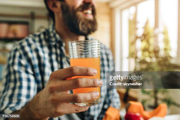 nahaufnahme eines mannes mit glas frischen saft zu hause. - orange juice stock-fotos und bilder