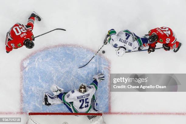 Michael Del Zotto of the Vancouver Canucks approaches the puck against John Hayden of the Chicago Blackhawks at the United Center on March 22, 2018...