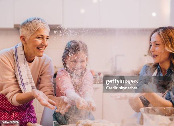 playful extended family having fun with flour in the kitchen. - making a cake stock pictures, royalty-free photos & images