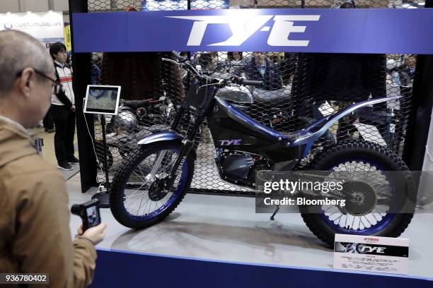 An attendee looks at a Yamaha Motor Co. TY-E electric trial bike on display at the Tokyo Motorcycle Show in Tokyo, Japan, on Friday, March 23, 2018....