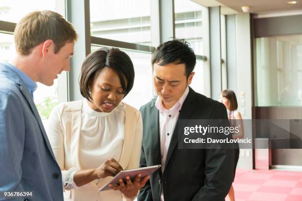 een zwarte vrouw bereidt collega's voor een zakelijke bijeenkomst in office gang in kyoto, japan - lypsekyo16 stockfoto's en -beelden