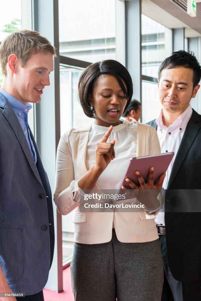 Eine schwarze Frau bereitet Kolleginnen und Kollegen vor ein Business-Meeting im Büro Korridor in Kyoto, Japan