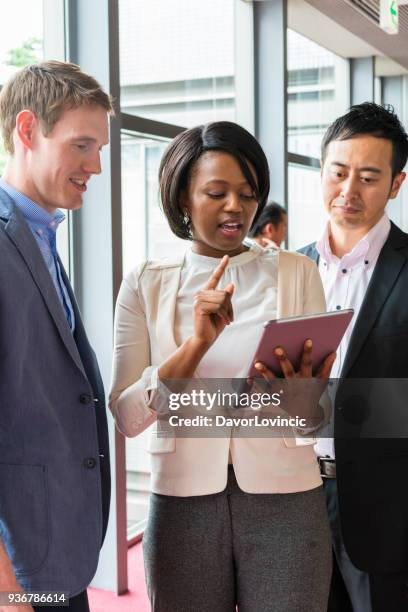 een zwarte vrouw bereidt collega's voor een zakelijke bijeenkomst in office gang in kyoto, japan - lypsekyo16 stockfoto's en -beelden