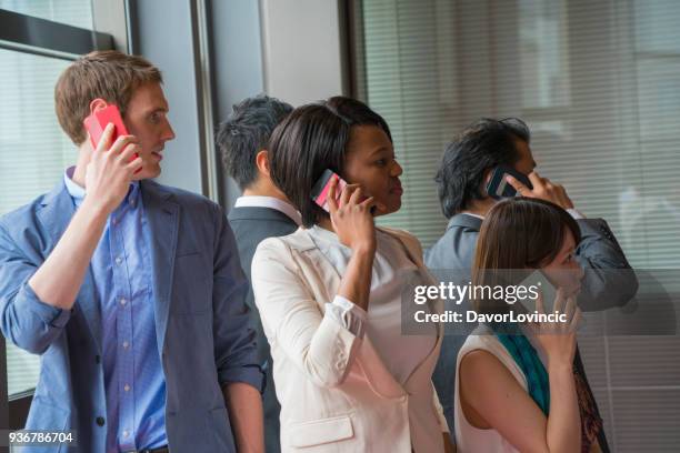 vijf multi-etnische mensen, gesprekken op mobiele telefoon tijdens zakelijke bijeenkomst breken in office gang in kyoto, japan - lypsekyo16 stockfoto's en -beelden