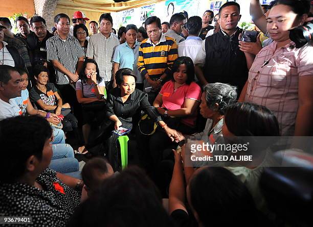 Philippine President Gloria Arroyo holds a dialogue with relatives of slain journalists during a visit at the wake in General Santos City, south...