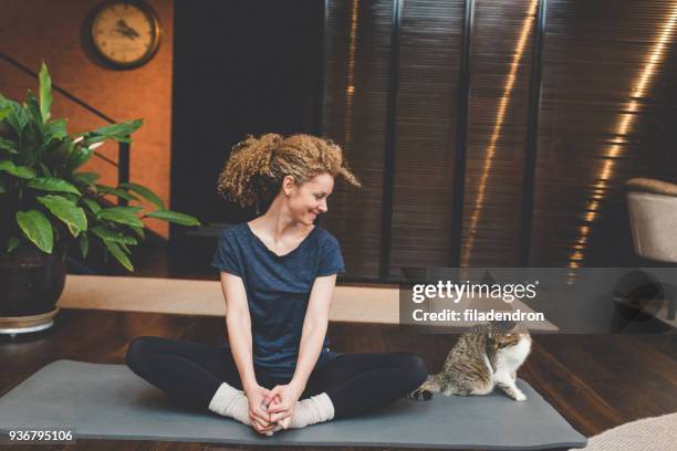 yoga zu hause üben - schneidersitz stock-fotos und bilder