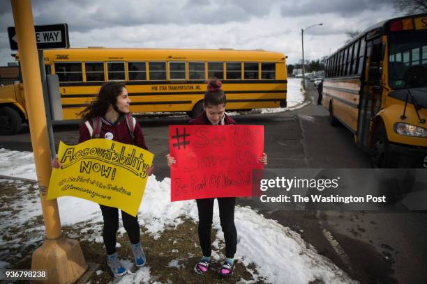 Student activists Stacy Gonzalez and Mariangely Ortiz hold signs during a protest across the street from Smith & Wesson's headquarters in...