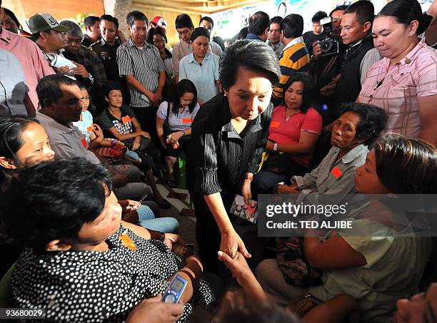 Philippine President Gloria Arroyo condoles with relatives of slain journalists during a visit at the wake in General Santos City, south Cotabato...