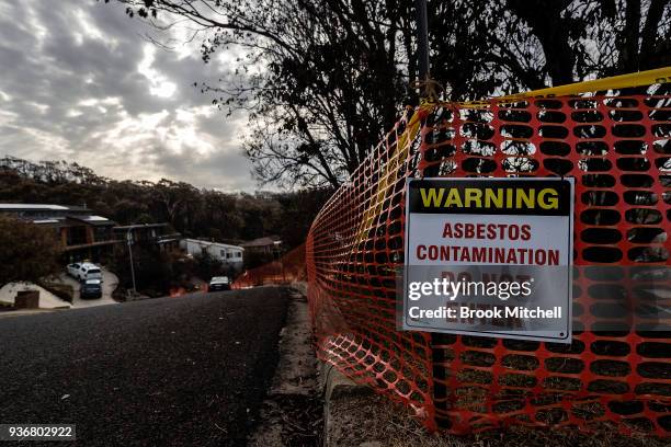 Sign warning of asbestos contamination is seen on a Tathra street on March 23, 2018 in Tathra, Australia. A bushfire which started on 18 March...