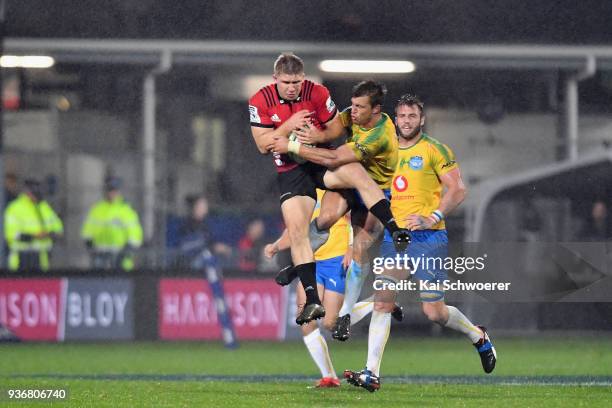 Jack Goodhue of the Crusaders is tackled by Handre Pollard of the Bulls during the round six Super Rugby match between the Crusaders and the Bulls on...