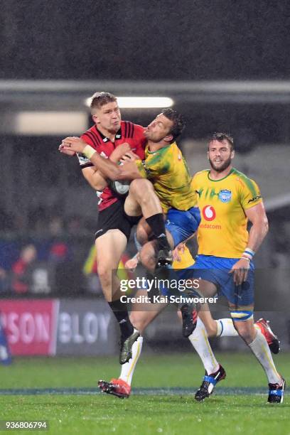 Jack Goodhue of the Crusaders is tackled by Handre Pollard of the Bulls during the round six Super Rugby match between the Crusaders and the Bulls on...