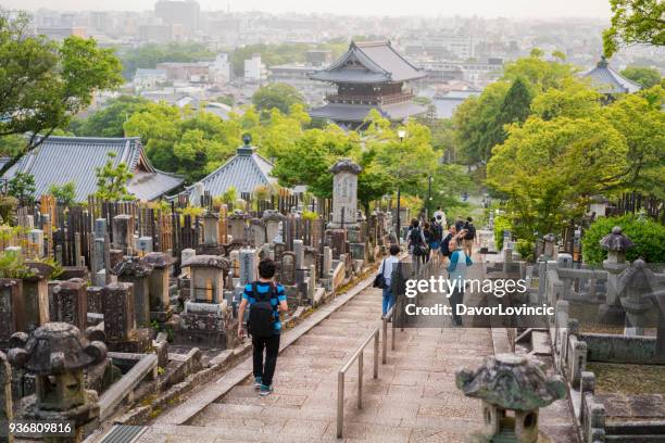 torists gå igenom kyrkogården i förgrunden och kyoto city stadsutbredning i bakgrunden - the cemetery for foreigners bildbanksfoton och bilder