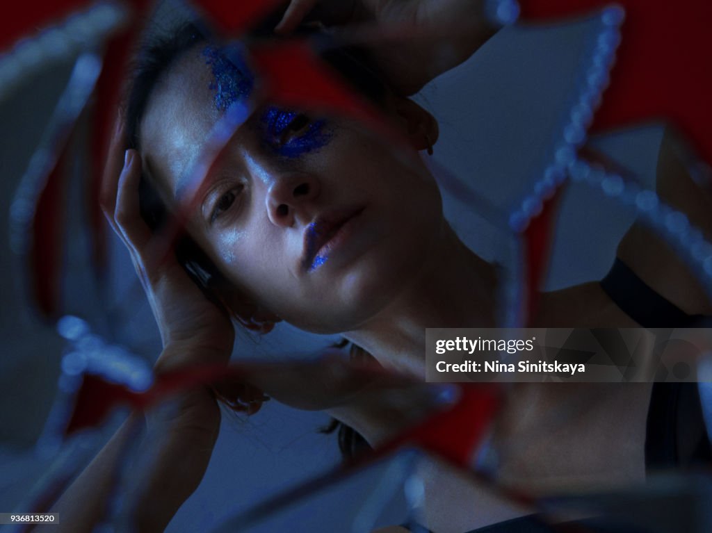 Reflection of woman in broken mirror
