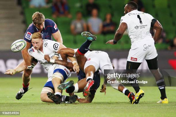 Jean-Luc du Preez of the Sharks passes the ball whilst being tackled by Geoff Parling of the Rebels during the round six Super Rugby match between...