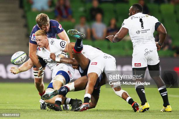 Jean-Luc du Preez of the Sharks passes the ball whilst being tackled by Geoff Parling of the Rebels during the round six Super Rugby match between...