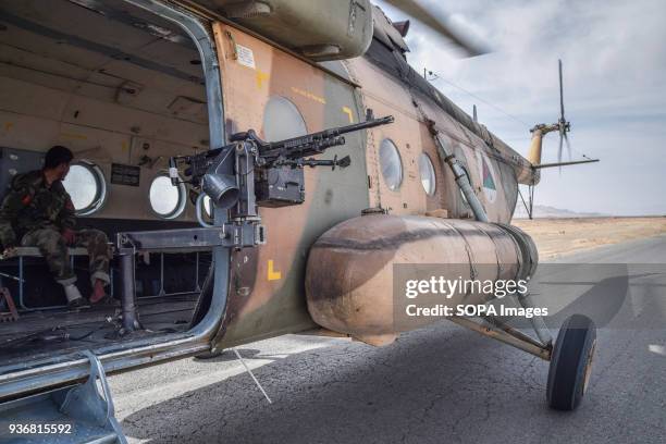 An Mi-17 helicopter of the Afghan Air Force, equipped with gun on the side door, sitting on the tarmac of the main road somewhere in Bolo Bluk...