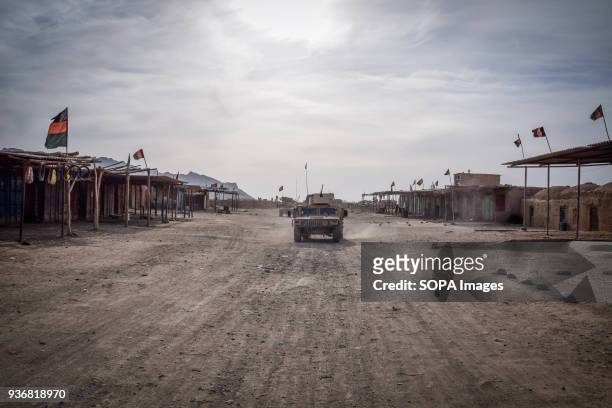 HMMWVs of the Afghan Commandos driving through an empty part of Farahrud Bazaar, Bolo Bluk district, Farah province, Afghanistan . Despite the many...