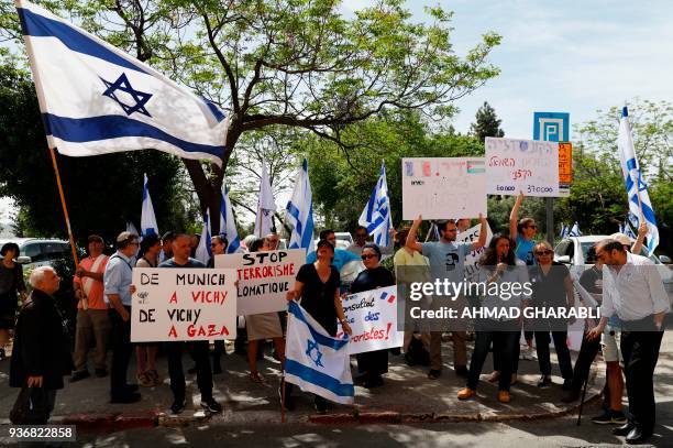 Israelis hold their national flag and posters during a demonstration outside the French Consulate in Jerusalem on March 23 after a French citizen and...