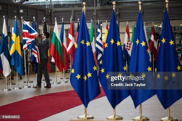 The Union Jack flag is arranged by an employee at the Council of the European Union on the final day of the European Council leaders' summit on March...