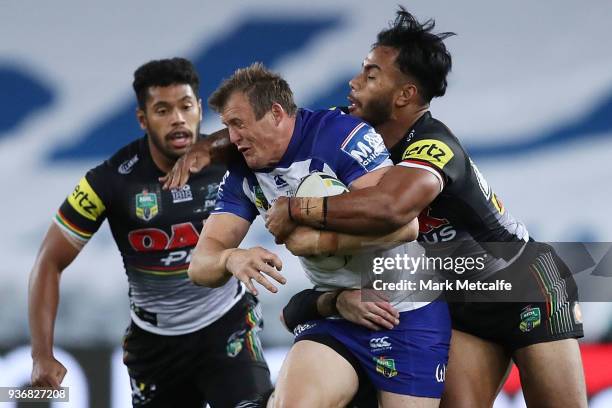 Josh Morris of the Bulldogs is tackled during the round three NRL match between the Bulldogs and the Panthers at ANZ Stadium on March 23, 2018 in...