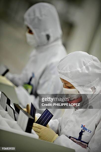Climate-warming-China-solar,FOCUS by D'Arcy Doran This picture taken on November 28, 2009 shows masked workers in a lab coat fire sorting silicon...
