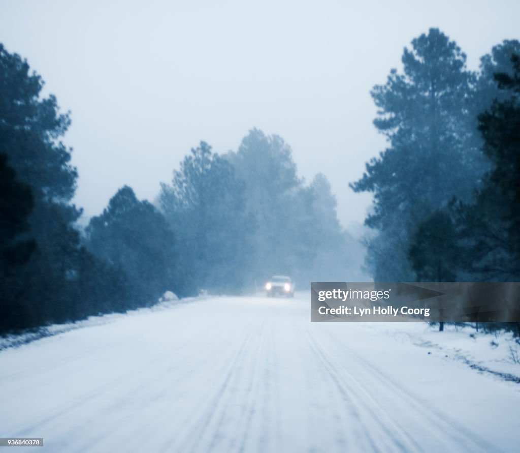 Defocused Car driving in snow along rural road