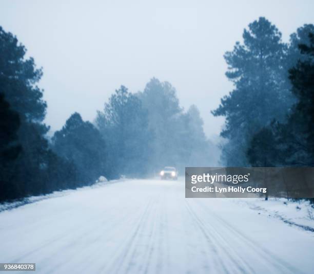 defocused car driving in snow along rural road - lyn holly coorg stock pictures, royalty-free photos & images