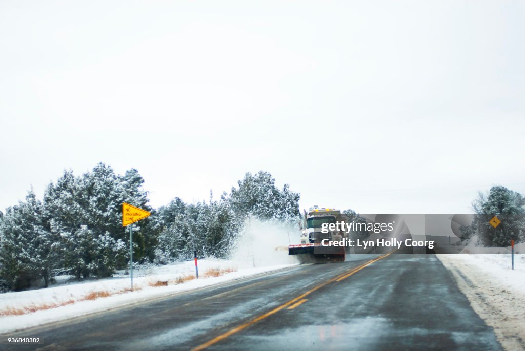 Snow plough clearing snow on roadside