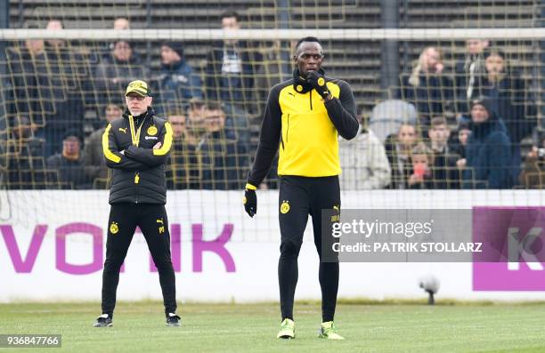 Retired Jamaican Olympic and World champion sprinter Usain Bolt stands next to Borussia Dortmund's head coach Peter Stoeger as he takes part in a...