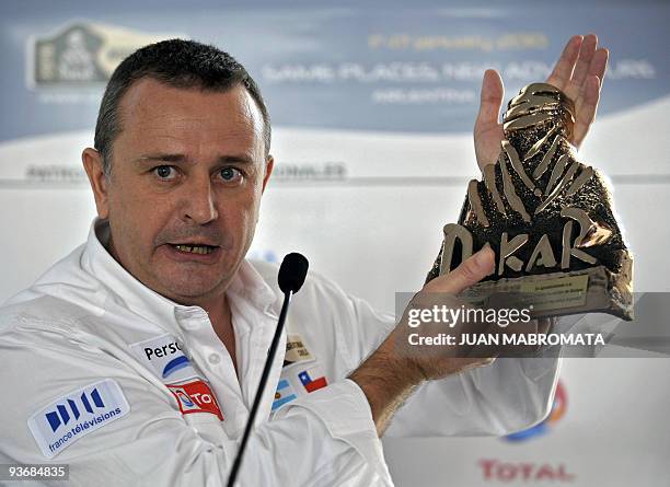 French director of the Dakar rally, Etienne Lavigne, shows a Dakar trophy, a present for Argentine President Cristina Fernandez de Kirchner in Buenos...